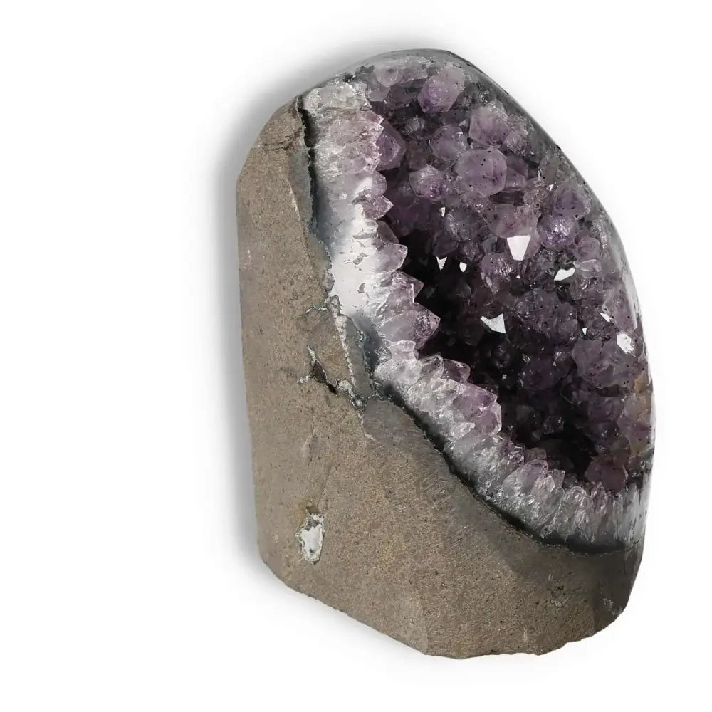 Amethyst cut base geode from Sylvia Crystals, showcasing its luxurious purple crystal formation, known for stress relief and focus enhancement.