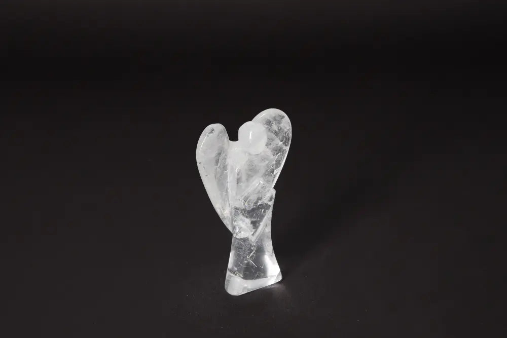 Clear quartz angel statue on black background, 11 cm tall, known for stress reduction and energy boost. Enhances emotional stability and focus.