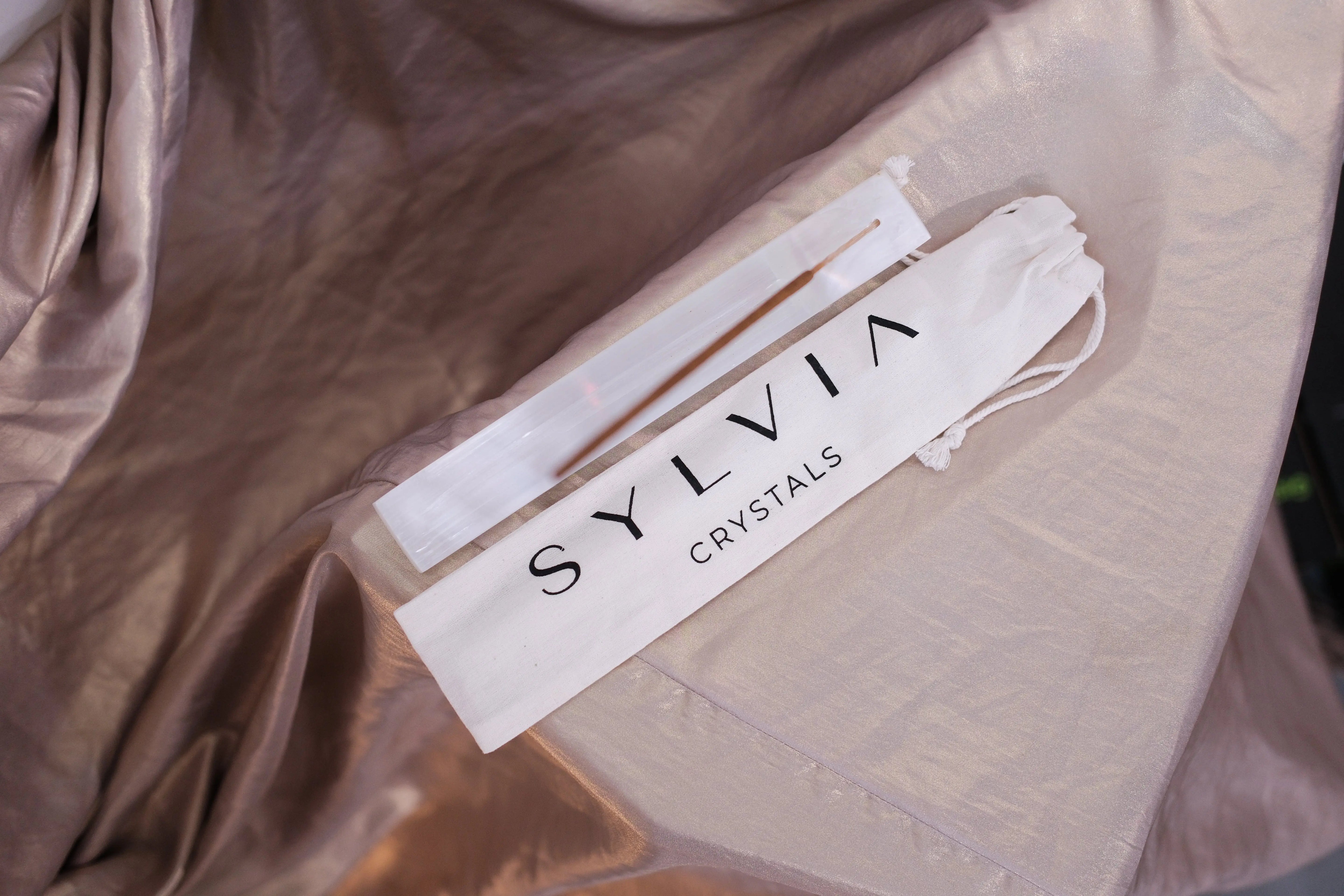 Elegant Sylvia Crystals packaging on satin fabric background, showcasing modern design and luxury branding.