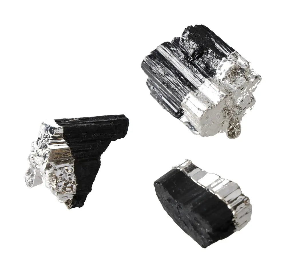 Raw black tourmaline mineral samples with silver accents on a white background.