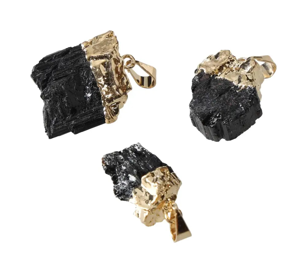 Black tourmaline pendants set in elegant gold finish, showcasing striking natural crystal texture, ideal for jewelry enthusiasts.