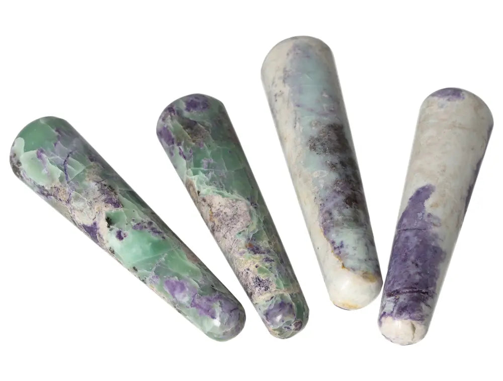 Four Bolivianite crystal wands in green and purple hues arranged side by side on a white background.