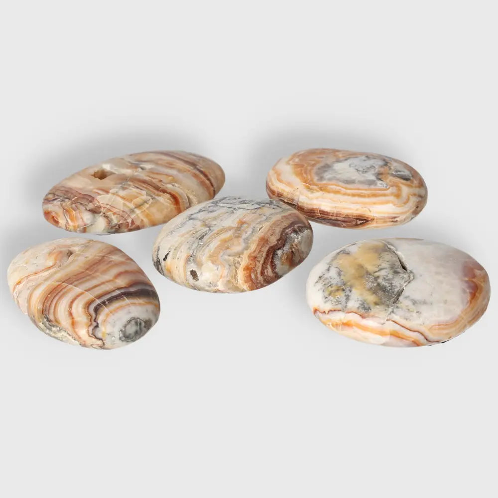 Five smooth Brown Aragonite palm stones with earthy tones, ideal for grounding and meditation.