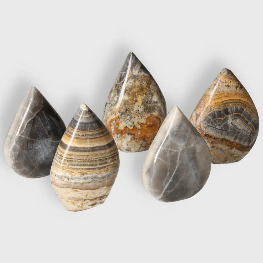 Polished Bumblebee Onyx gemstones showcasing vibrant yellow, black, and white bands, symbolizing strength and balance.