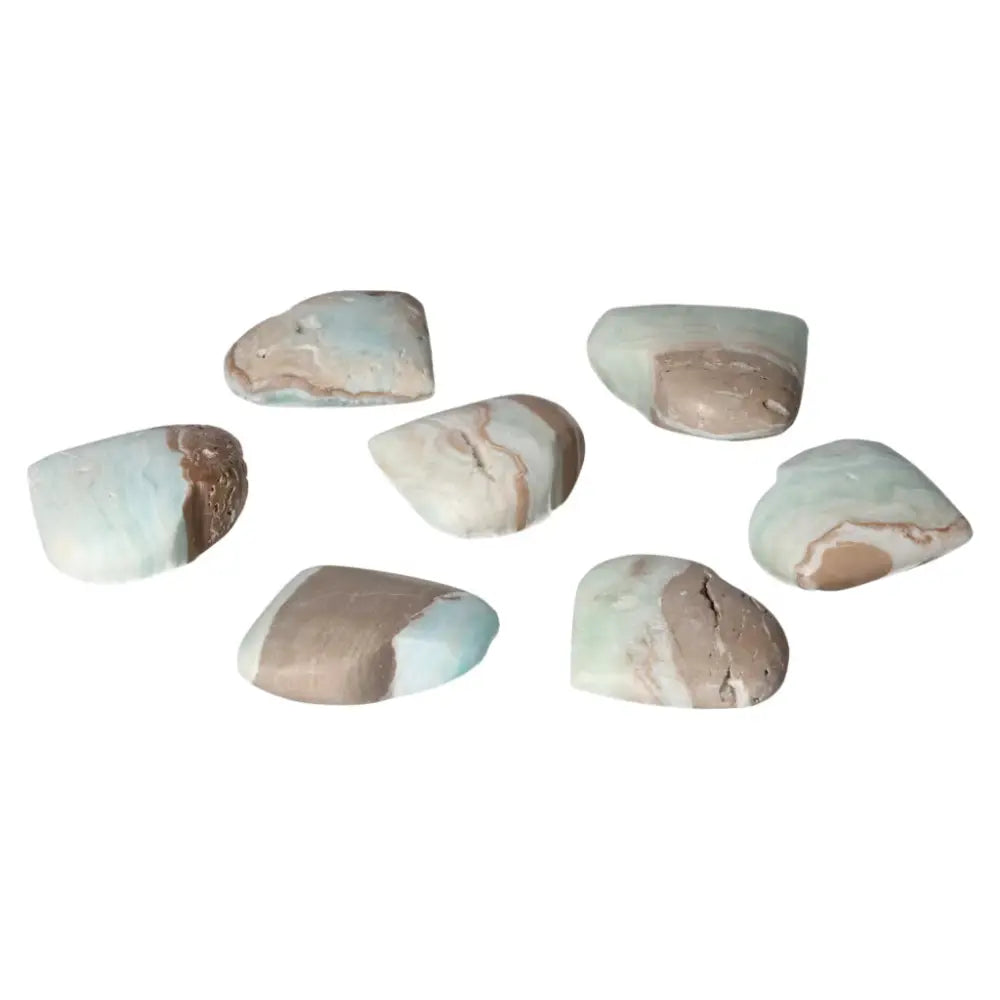 Assorted Caribbean Calcite heart-shaped crystals on white background, featuring soothing blue and creamy white colors, from Sylvia Crystals.