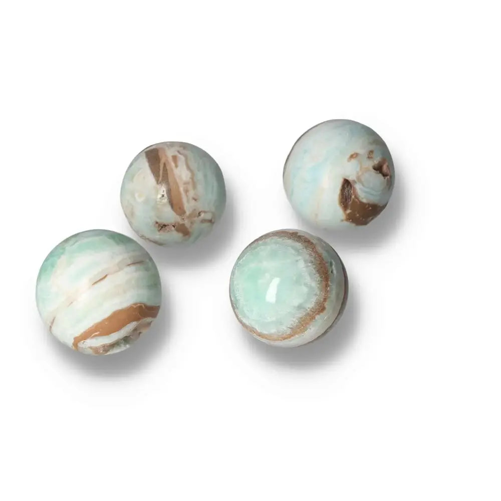 Caribbean Calcite spheres with serene blue and white hues, symbolizing peace and spiritual insight, offered by Sylvia Crystals.