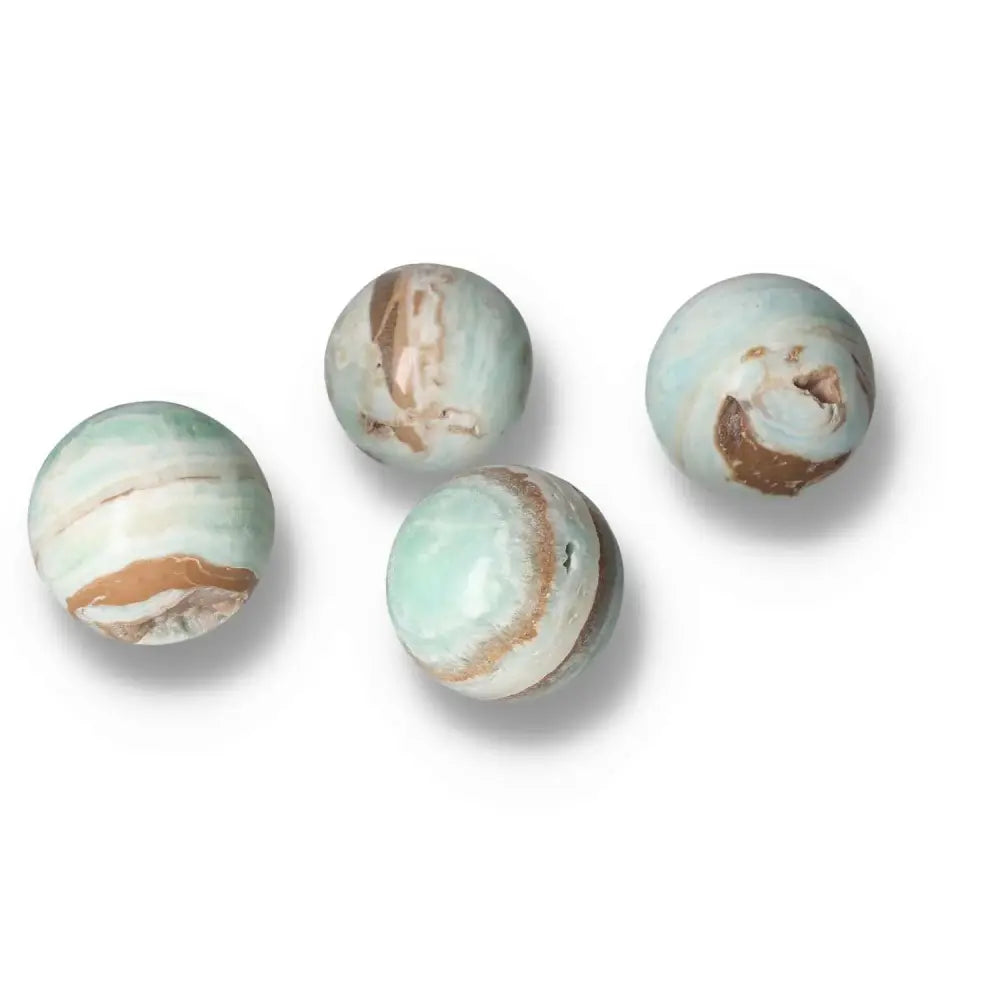 Caribbean Calcite spheres M showcasing serene blue and white hues, a symbol of peace and spiritual insight from Sylvia Crystals.