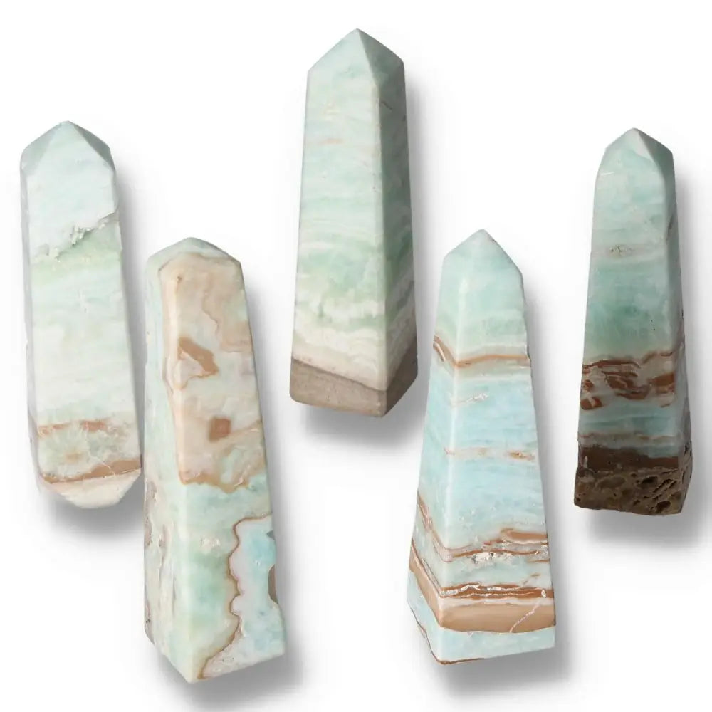 Five Caribbean Calcite towers with serene blue and white hues, showcasing premium quality from Sylvia Crystals for spiritual balance.