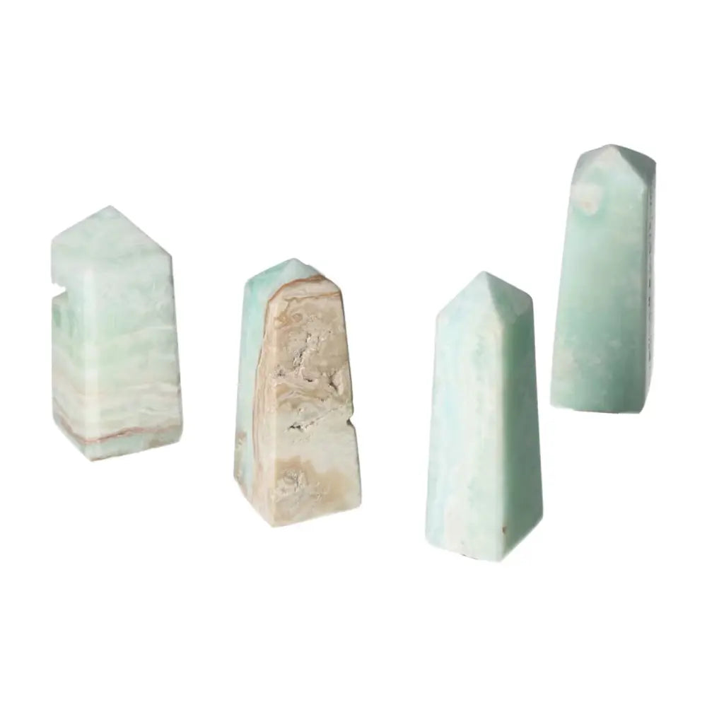 Four Caribbean Calcite crystal towers displaying calming blue and white hues from Sylvia Crystals, evoking ocean tranquility.