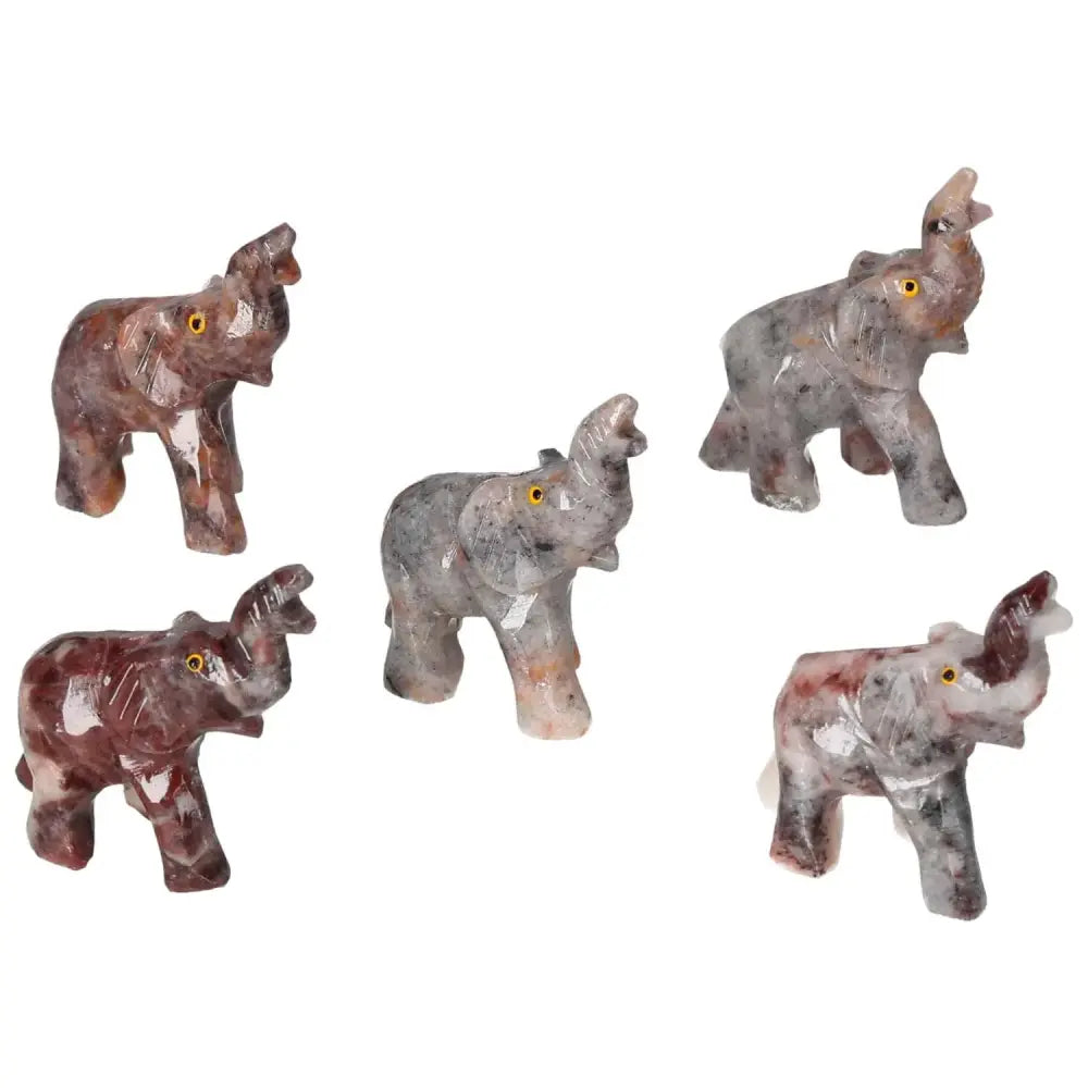 Five carved crystal elephant figurines made of magnesite, showcasing intricate designs and spiritual elegance from Sylvia Crystals.
