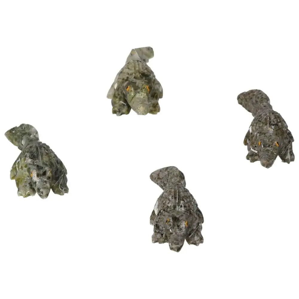 Four intricately carved dolomite alligator figures showcasing detailed craftsmanship and natural stone patterns.