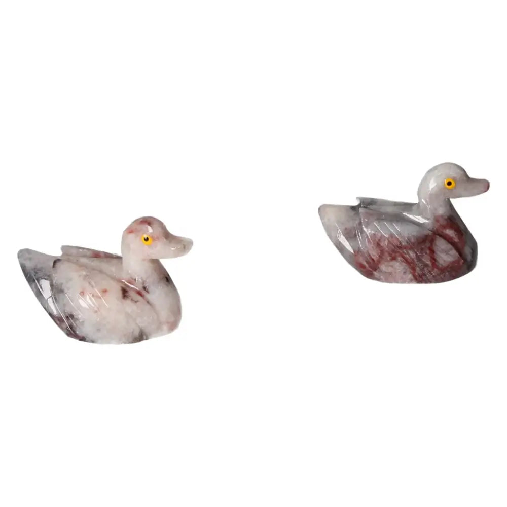 Two hand-carved dolomite duck sculptures with marbled patterns, embodying elegance and luxury for home decor or spiritual wellness.