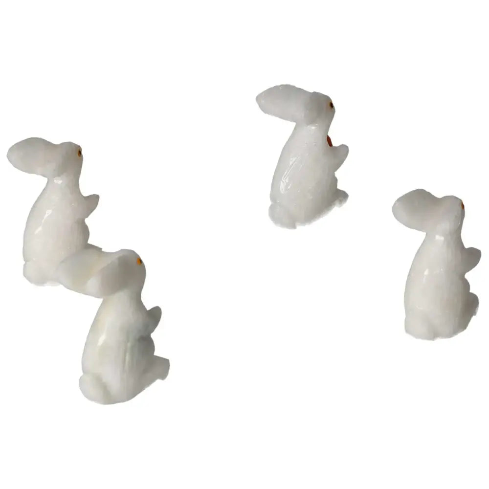 Four carved dolomite rabbit figurines, showcasing serene elegance and spiritual balance, ideal for home or office decor.