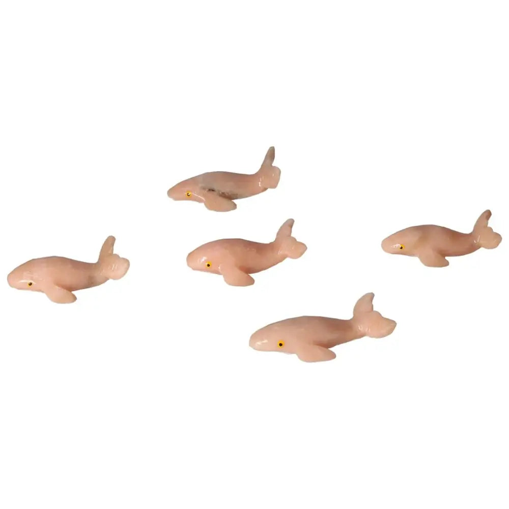Group of five carved dolomite whale figurines from Sylvia Crystals, showcasing exquisite craftsmanship and natural elegance.
