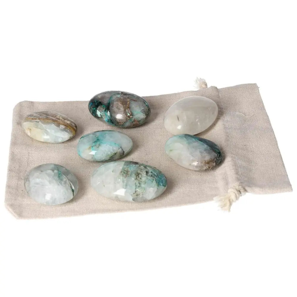 Chrysocolla palmstone collection on fabric bag, enhancing communication skills and emotional understanding with feminine energy focus.