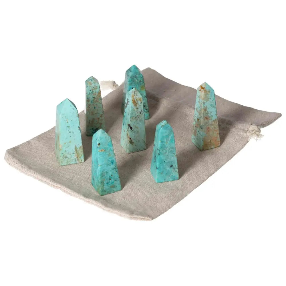 Set of six Chrysocolla Towers on a beige cloth showcasing their vibrant blue-green hues and natural patterns, ideal for energy healing.