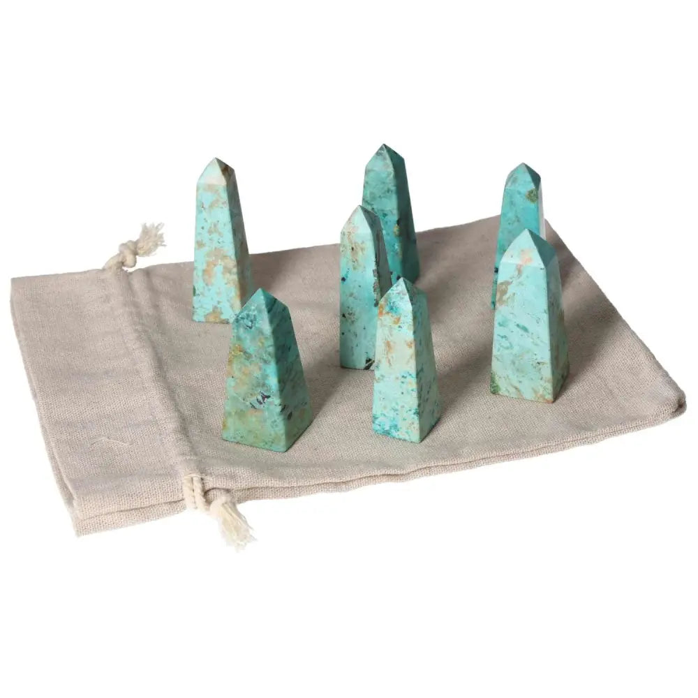 Chrysocolla towers on cloth bag, enhancing communication and emotional understanding with feminine energy, ideal for speakers.