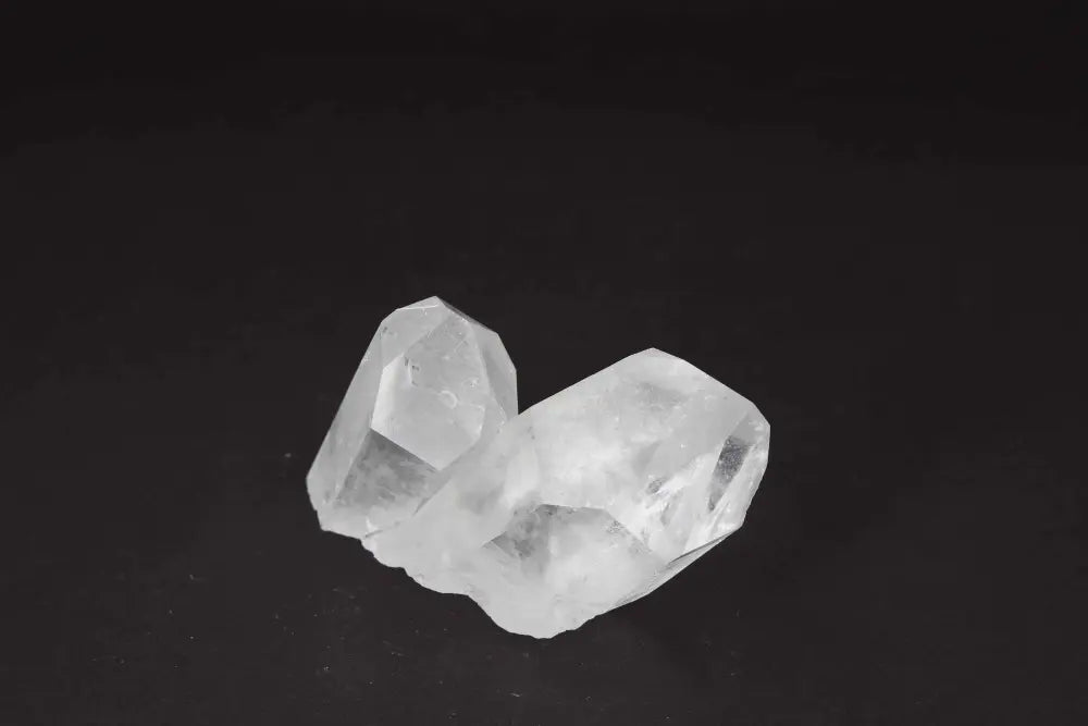 Clear Quartz Cluster on black background, showcasing crystal points for energy amplification and purification.