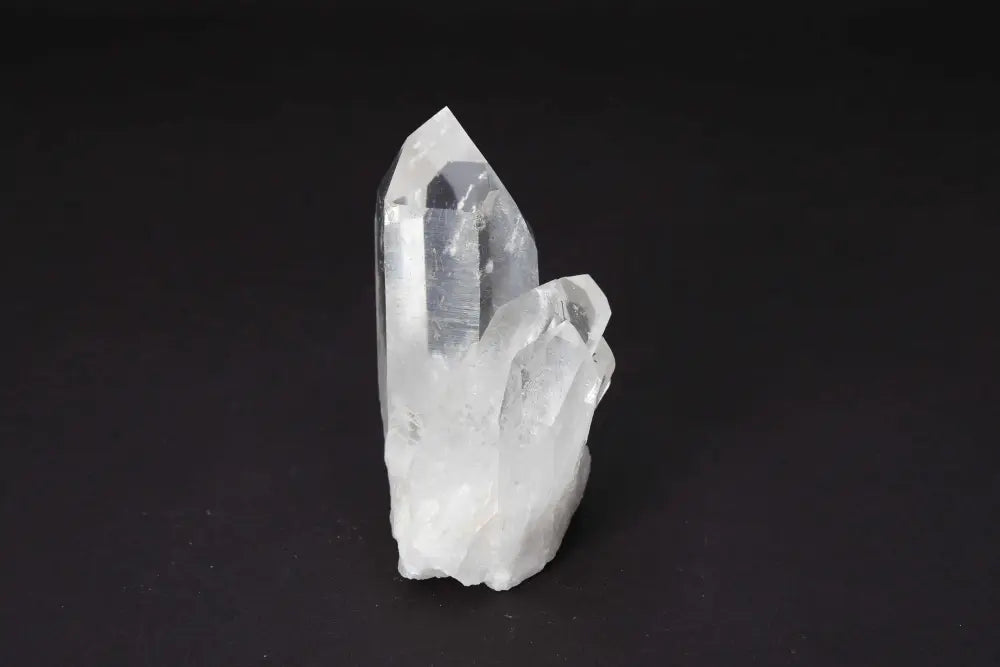 Clear Quartz Cluster - Natural crystal formation with multiple points, amplifying energy and clarity on a dark background.