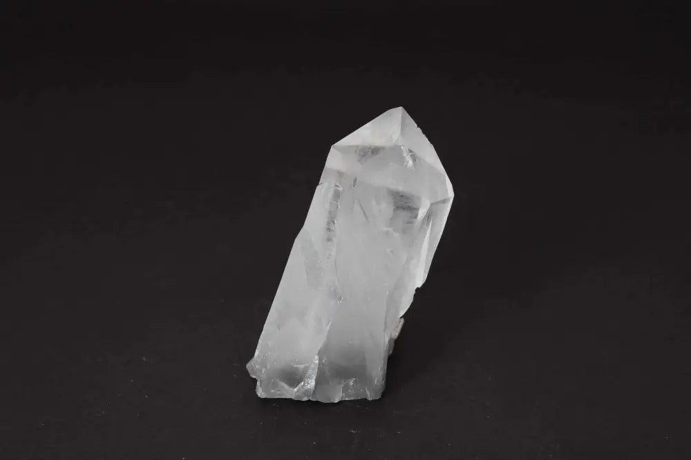 Clear quartz cluster on black background, amplifying energy and clarity through multiple crystal points on a shared matrix.