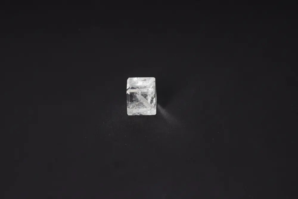 Clear Quartz Cube 2.5 cm on black background, a powerful purification stone harmonizing body, mind, and energy, dispelling negativity.