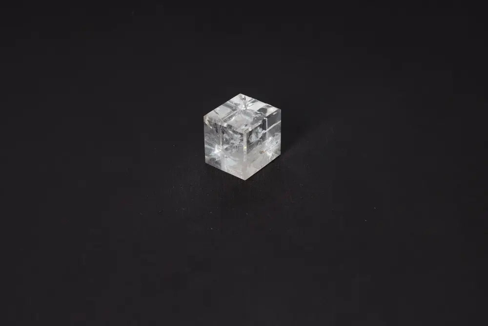 Clear Quartz Cube 3 cm for purification and positive energy on black background.