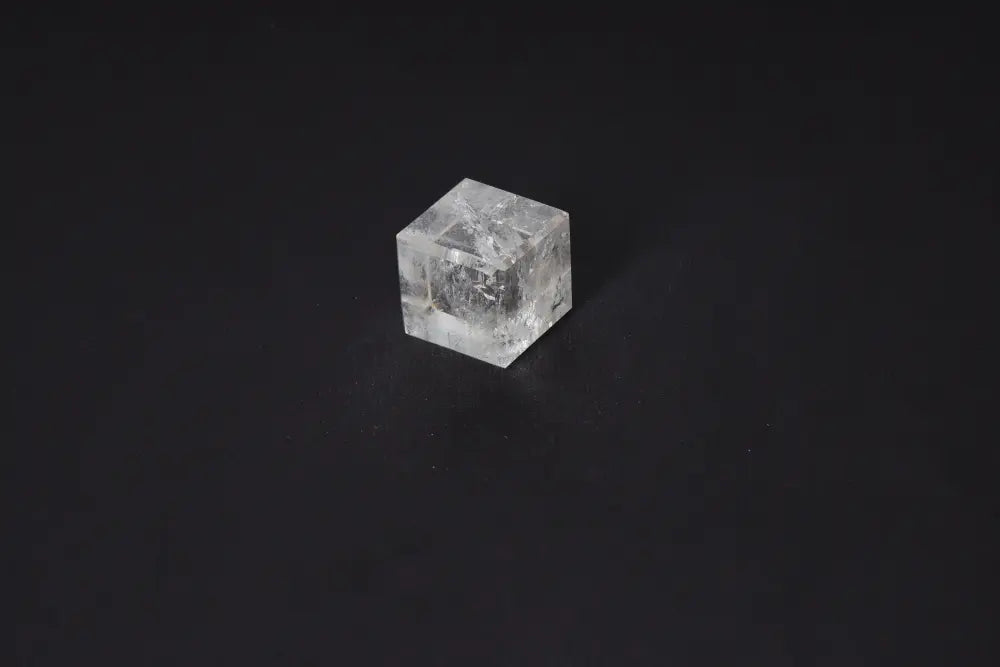 Clear Quartz Cube 3.5 cm on dark background, used for purification and harmonizing energy, dispelling negative thoughts and emotions.