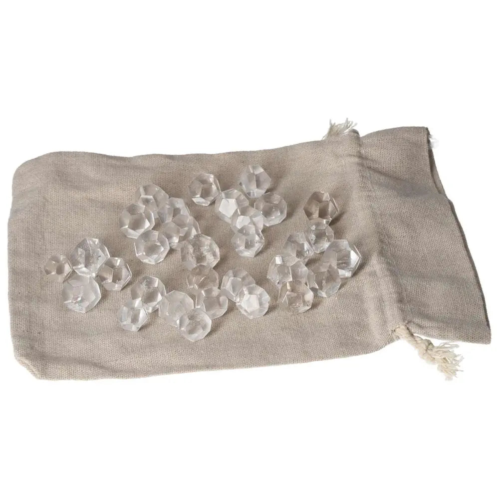 Clear Quartz small geometric spheres on a beige fabric pouch, perfect for energy purification and harmonizing the environment.