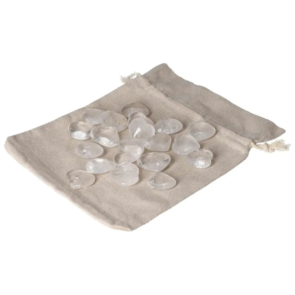 Pile of small clear quartz heart stones on a beige fabric bag, ideal for harmonizing energy and absorbing negative vibrations.