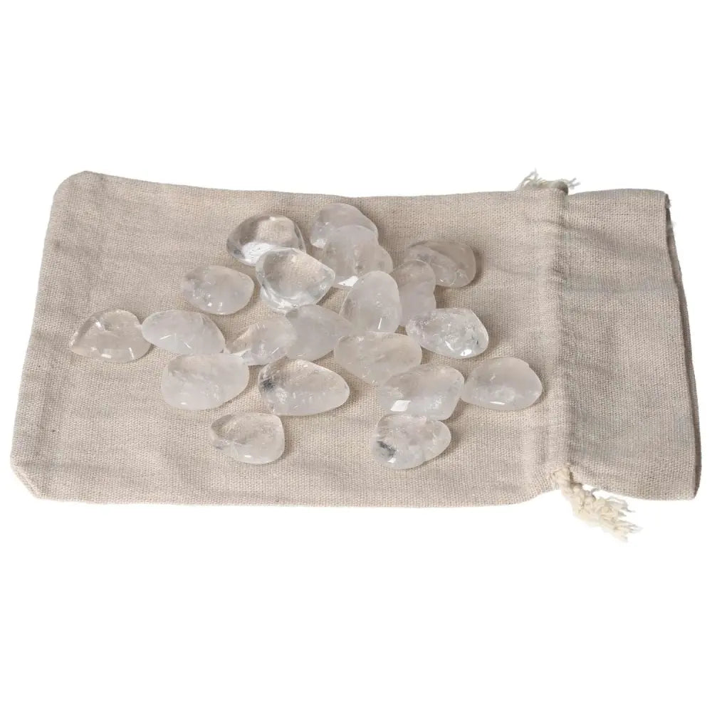Clear quartz stones on a beige cloth bag, used for purification, harmonizing energy, and dispelling negative vibrations.