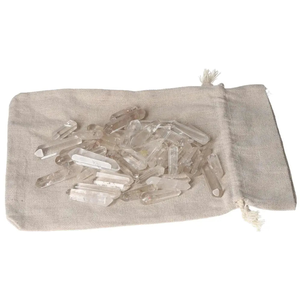 Clear Quartz small sticks on a beige fabric pouch, used for purification and harmonizing energy, ideal for absorbing negative vibrations.