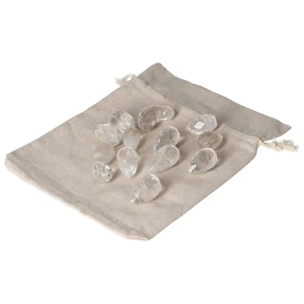 Clear Quartz small tear stones on beige fabric pouch, ideal for energy purification and neutralizing negative vibrations.