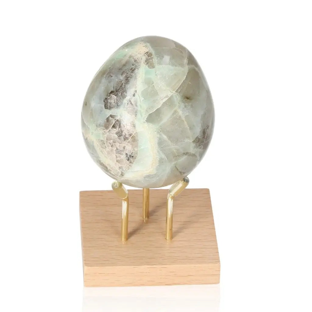 Feldspar with Quartz Egg from Sylvia Crystals, ideal for emotional healing and stress relief, displayed on a wooden stand.
