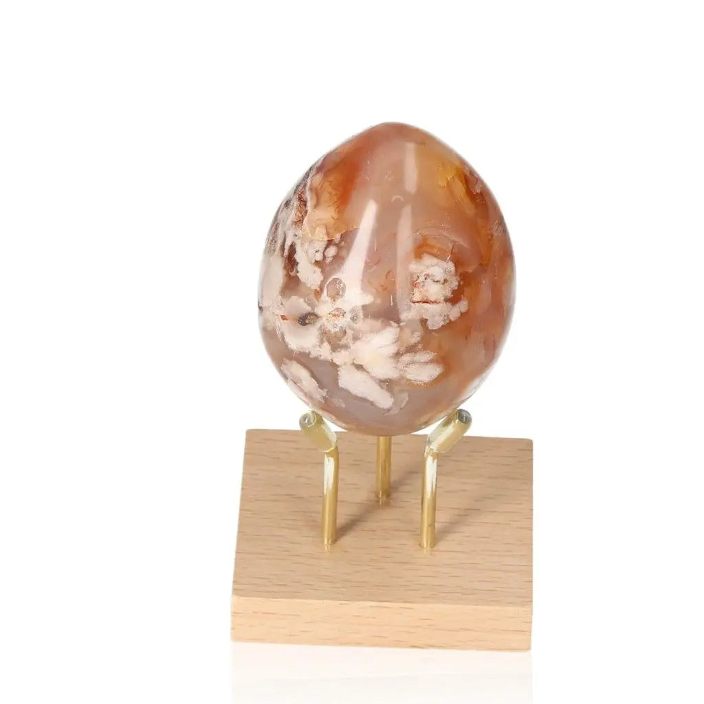 Flower Agate Egg crystal on a stand, showcasing blossom-like patterns, symbolizing growth and healing with soothing energy.