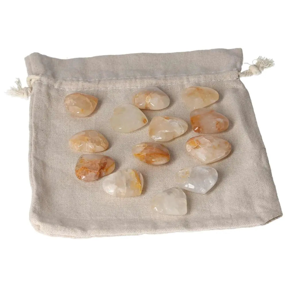 Golden Healer small heart stones on a beige drawstring pouch, perfect for crystal healing and decor.