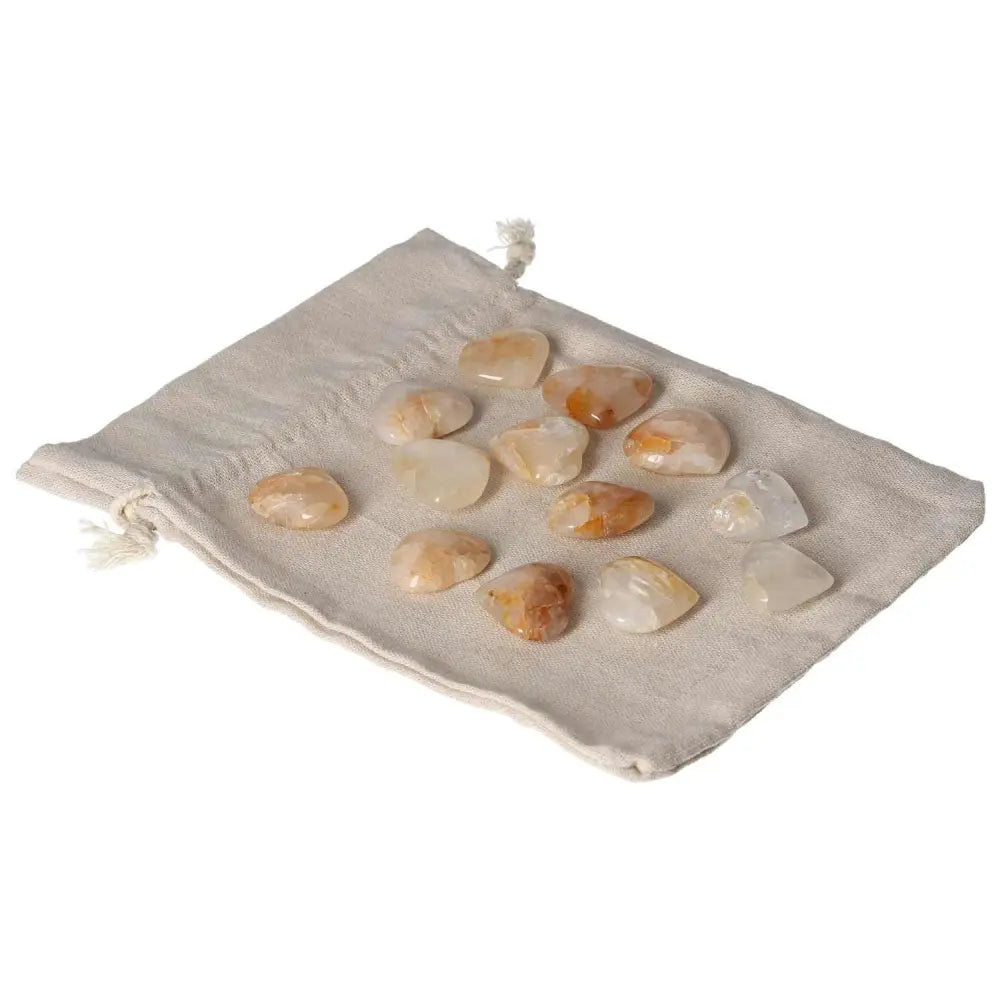 Golden Healer small heart stones on a beige pouch, showcasing crystal energy and healing properties.