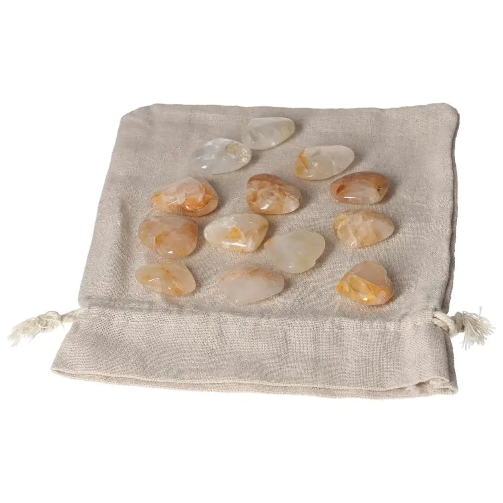 Golden Healer crystals on a beige cloth bag, showcasing small polished stones in warm golden hues.