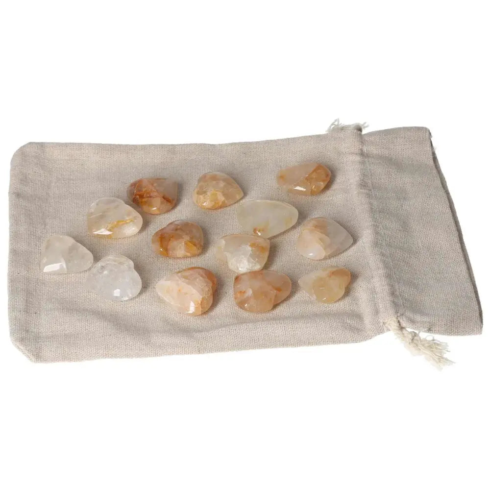 Golden Healer small heart-shaped crystals on a beige cloth bag, ideal for healing and wellness uses.
