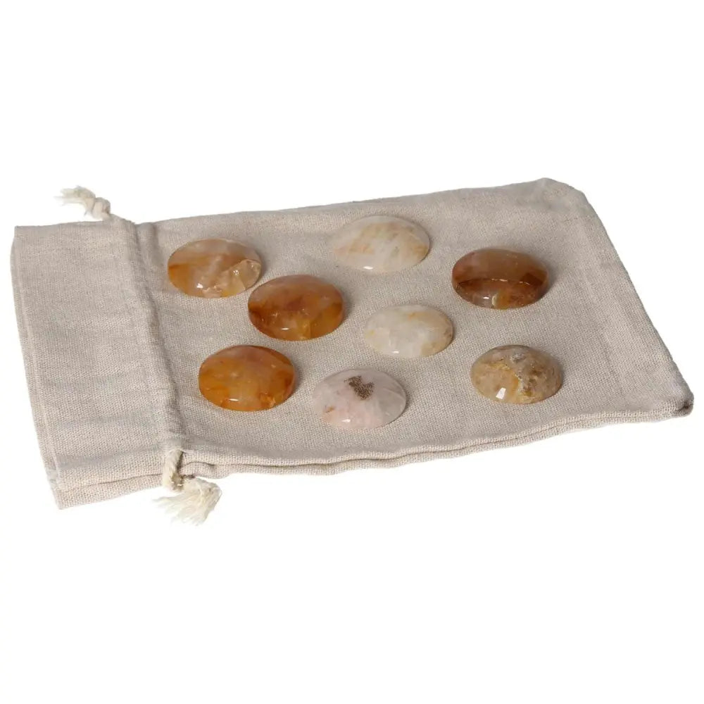Golden Healer small palmstones displayed on a beige fabric pouch.