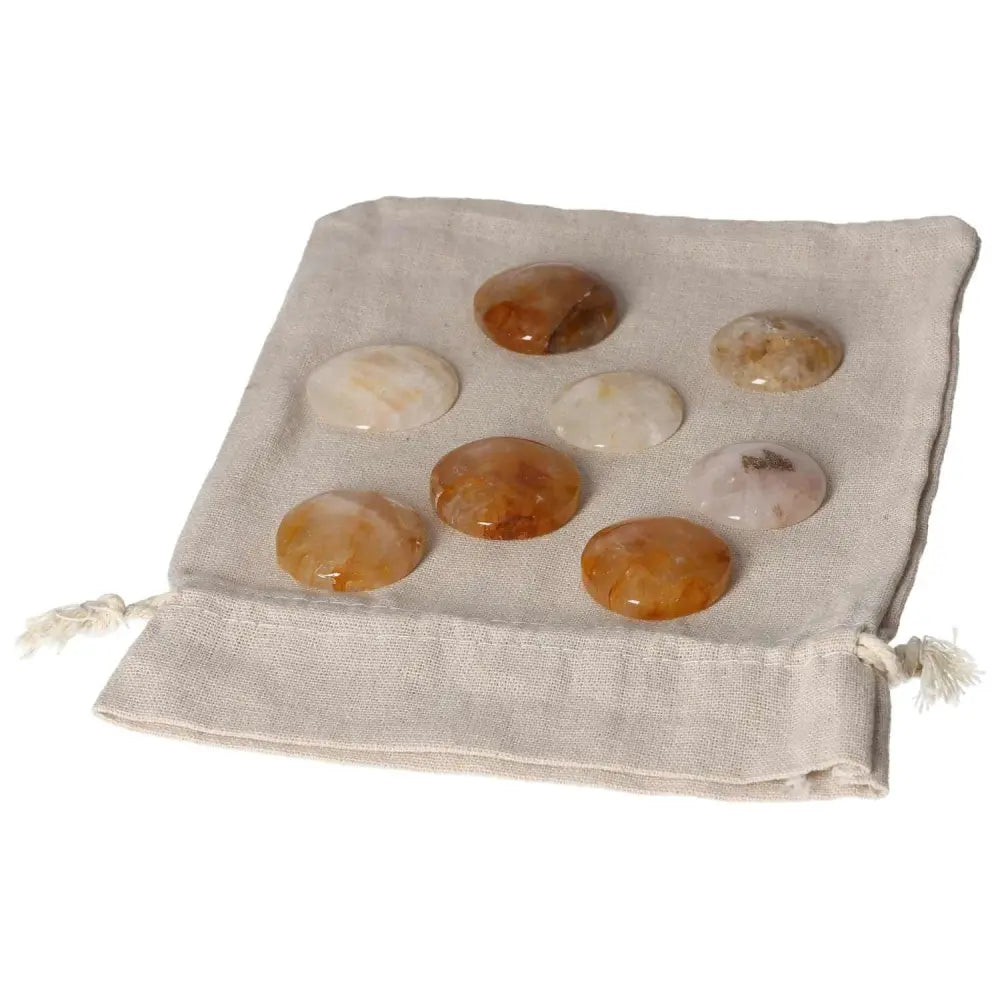 Golden Healer small palmstones on a beige drawstring pouch.