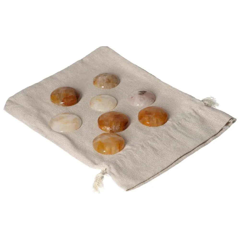 Golden Healer small palmstones placed on a beige cloth, showcasing their healing energy properties and natural golden hues.