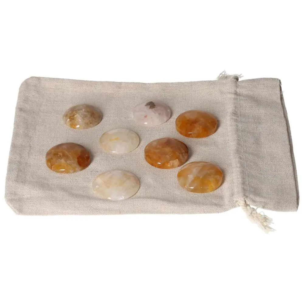 Golden Healer small palmstones on a beige cloth bag, enhancing relaxation and healing, glowing with natural golden hues."}