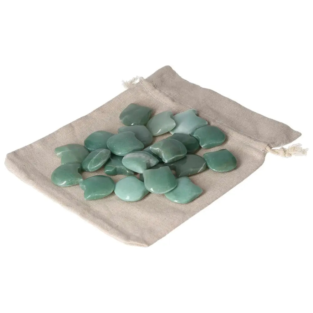 Green Aventurine stones on a beige cloth bag, known for boosting self-confidence and attracting luck and prosperity.