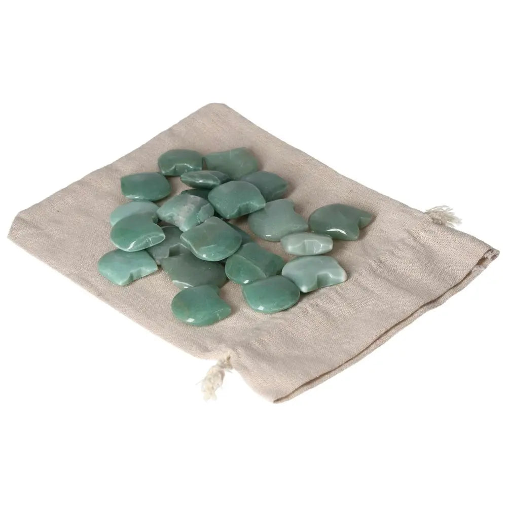 Small green aventurine stones on a beige drawstring cloth bag, symbolizing luck and prosperity.