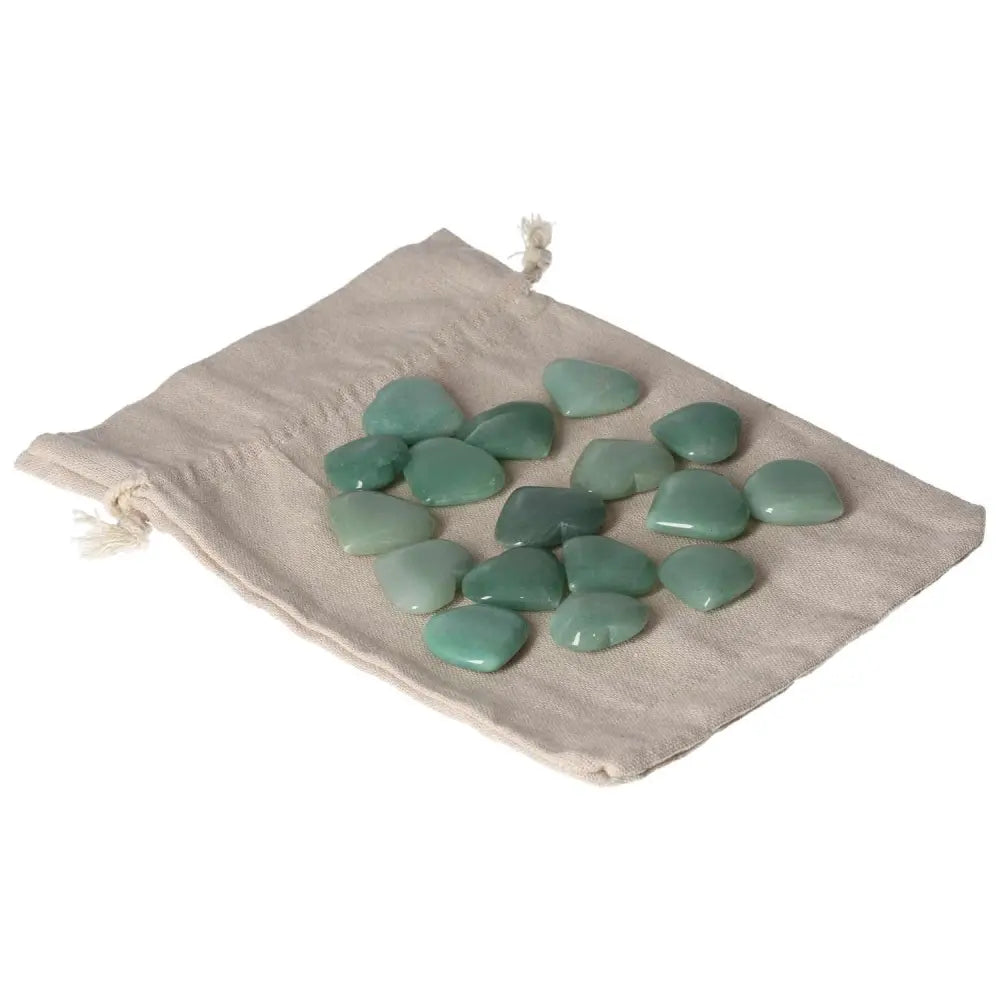 Collection of polished green aventurine stones on a beige cloth, offering calming and luck-attracting properties.