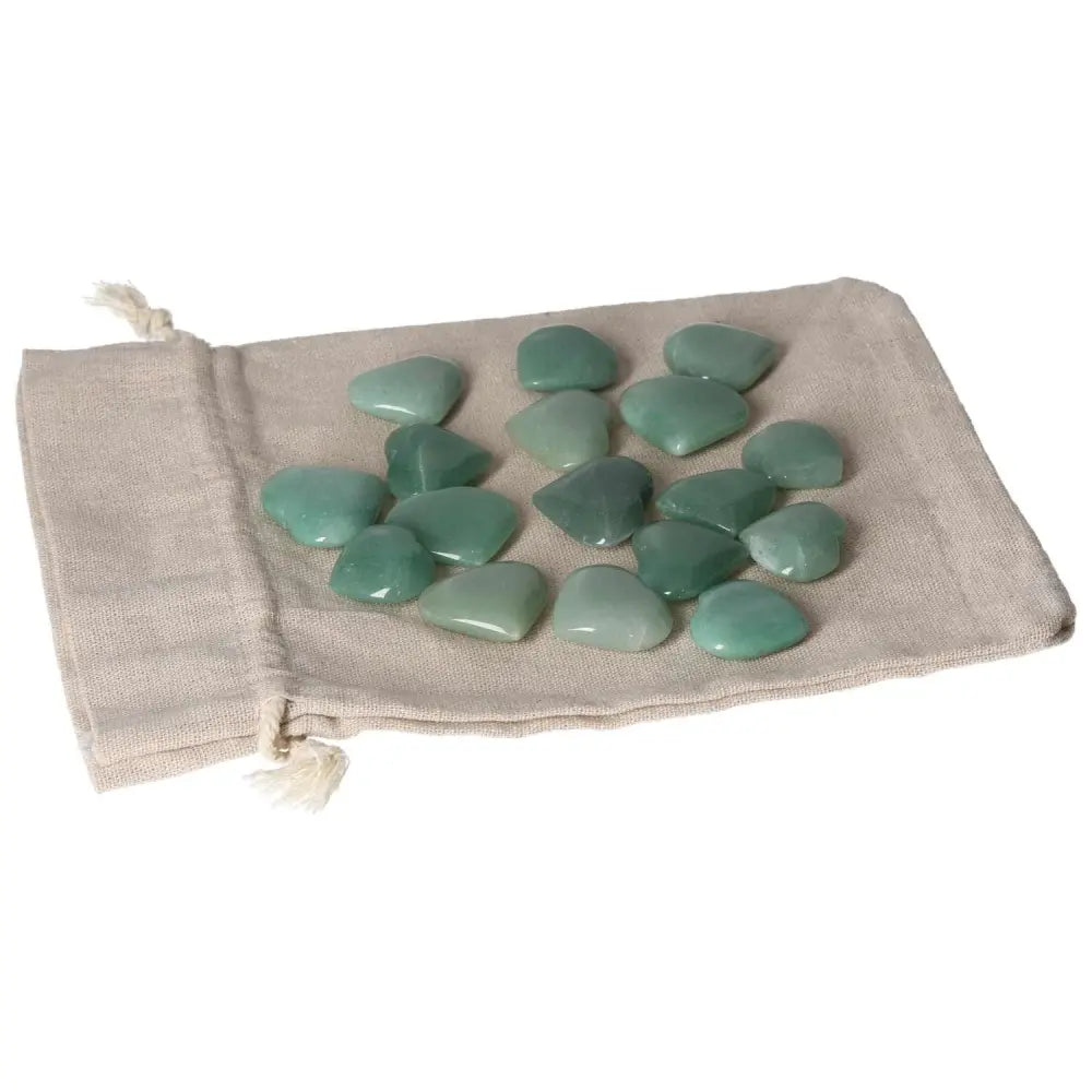 Green Aventurine small hearts on beige fabric, promoting self-confidence, luck, and inner peace.