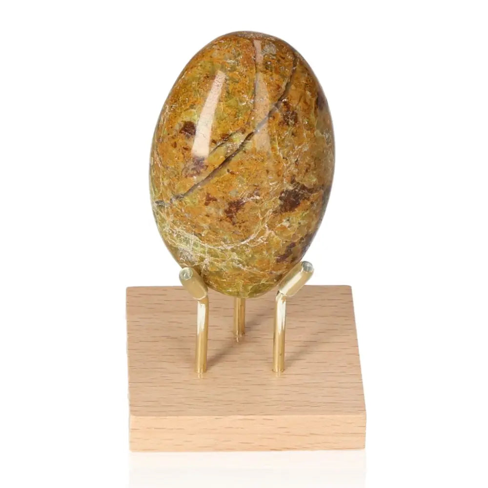Green Opal freeform stone on wooden stand showcasing healing and renewal energy with its soft green hues.