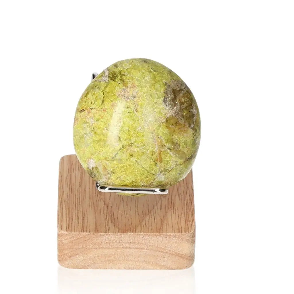 Green Opal Freeform gemstone on wooden stand, showcasing its soft green hues and nurturing properties for renewal and emotional balance.