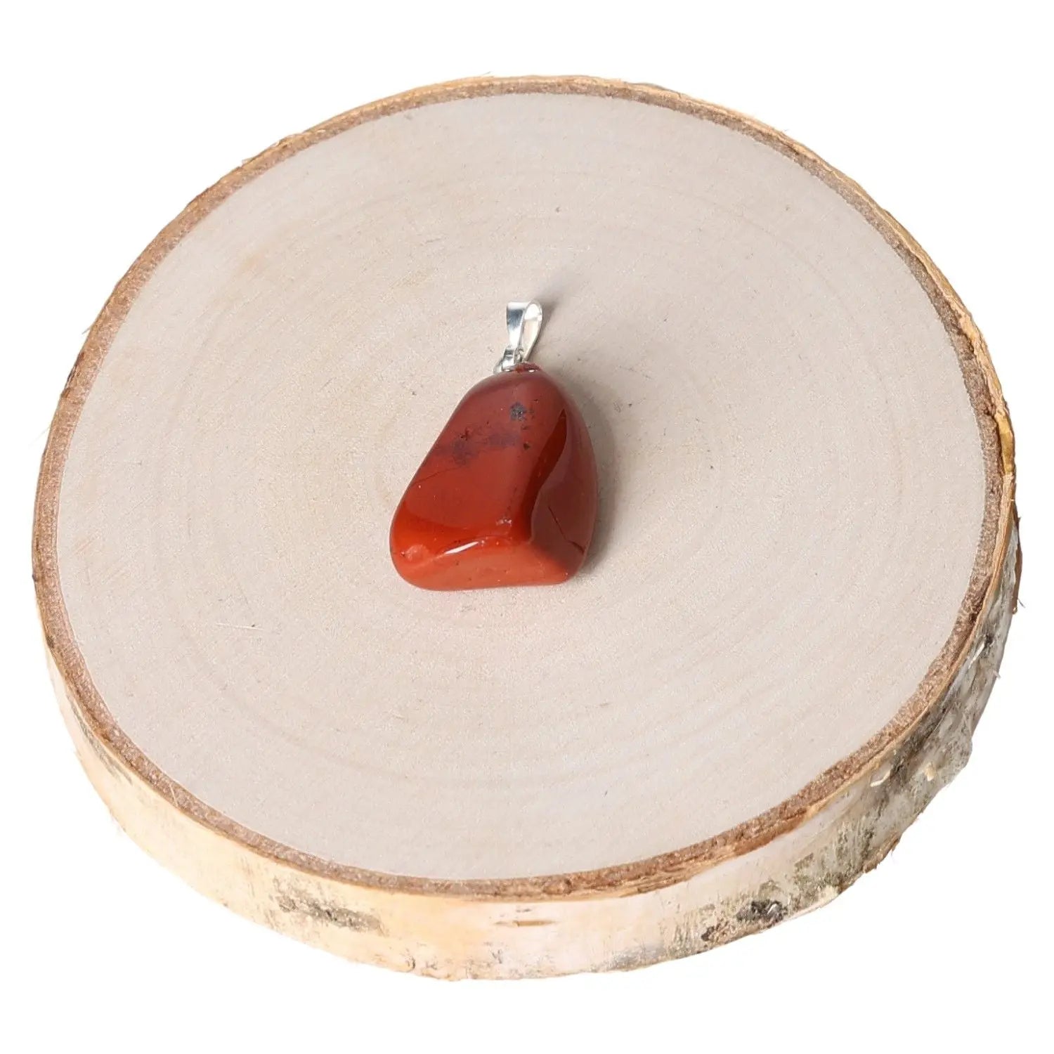 Jasper Red Tumbled Pendant showcasing a smooth, polished red stone on a wooden background, symbolizing strength and elegance.