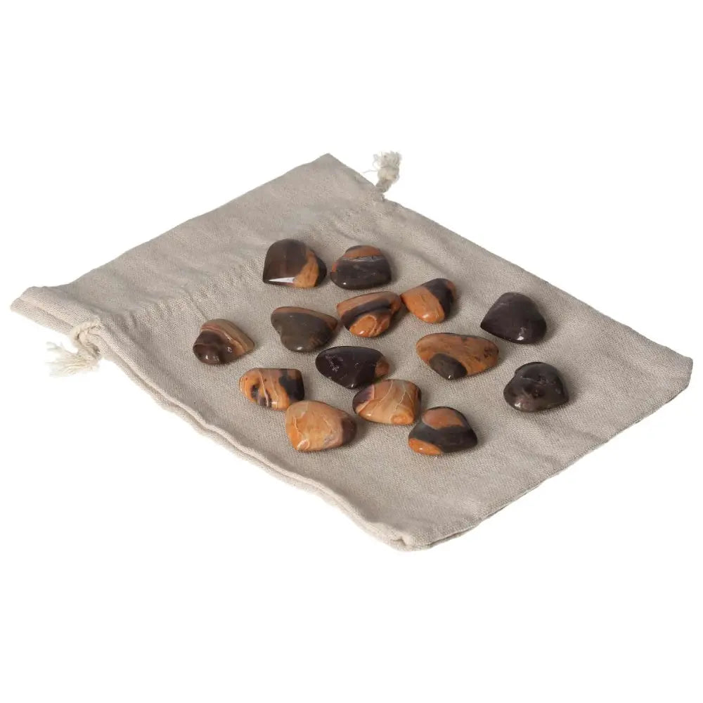 Polished Jasper Tiger stones on a beige drawstring pouch for harmony and balance.